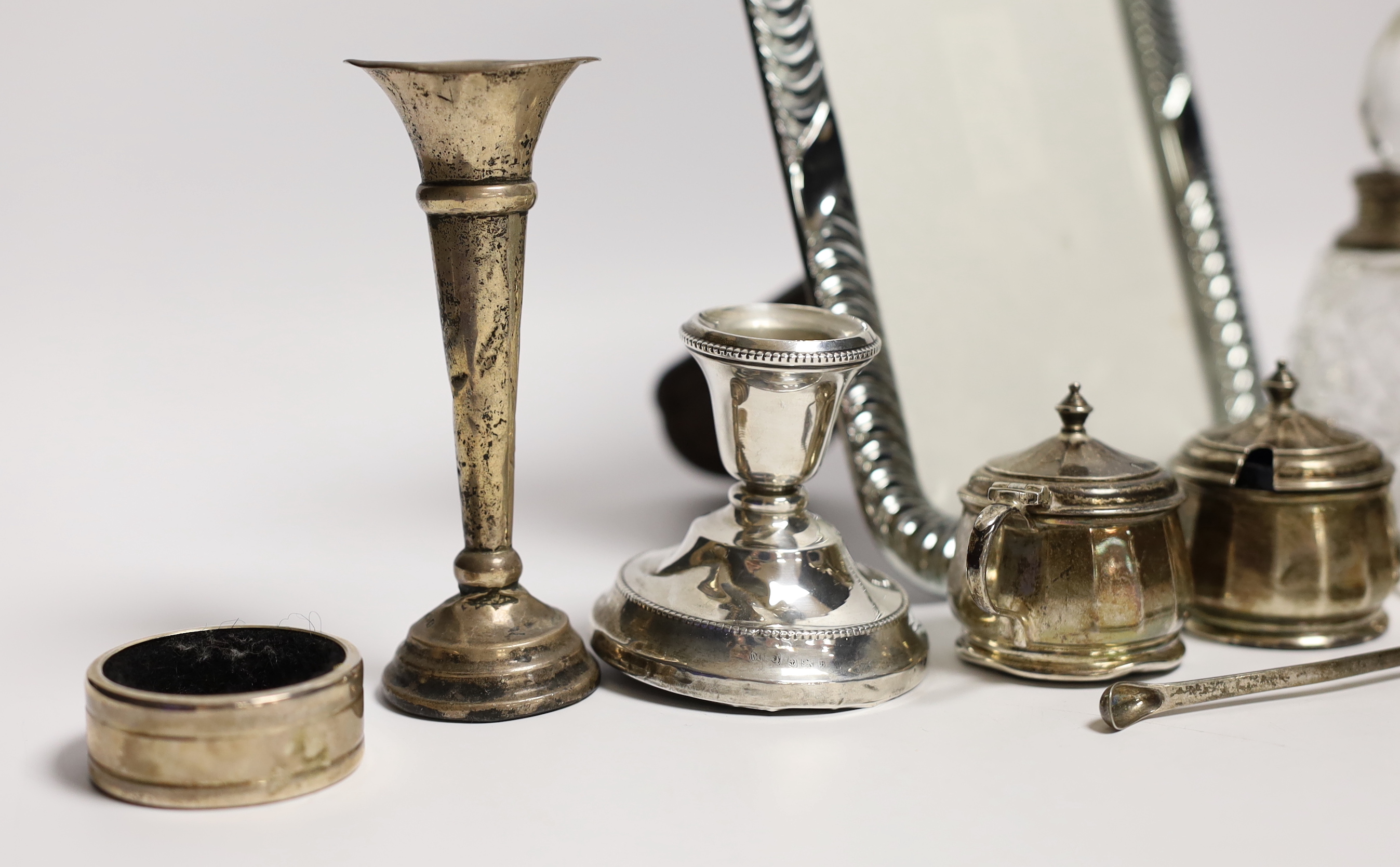 Sundry small silver including a pair of dwarf candlesticks, condiments, napkin ring, spill vases and a modern 925 mounted photograph frame.